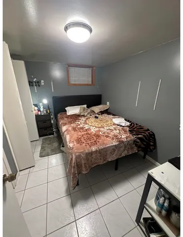 a bedroom with a bed and a mirror on the dresser