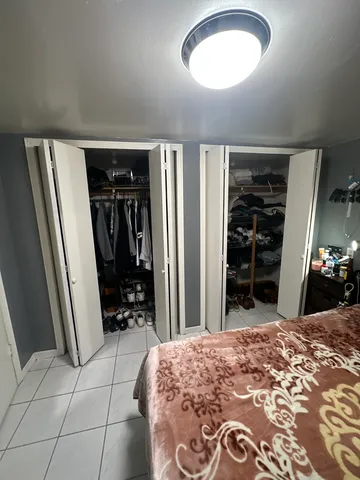 a bedroom with a bed and a large mirror on the dresser