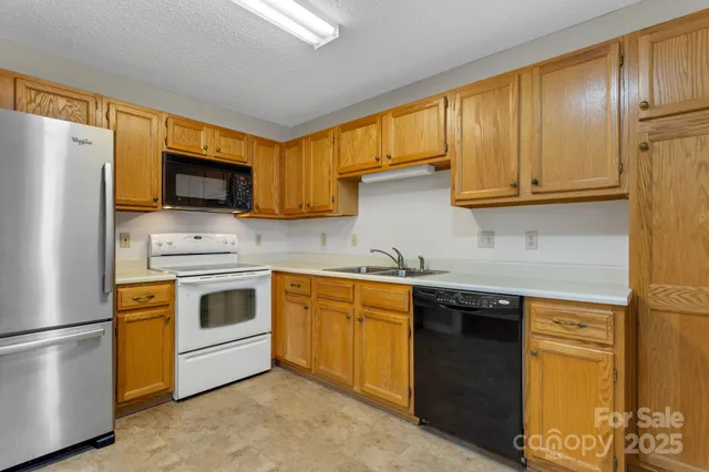 a kitchen with stainless steel appliances granite countertop a refrigerator sink stove microwave and cabinets