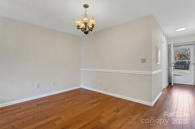 a view of a room with wooden floor and cabinets
