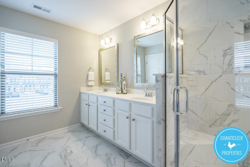 1119 Midtowne Way Durham, NC 27713 - Photo 16 of 26 a bathroom with a double vanity sink a mirror and a shower