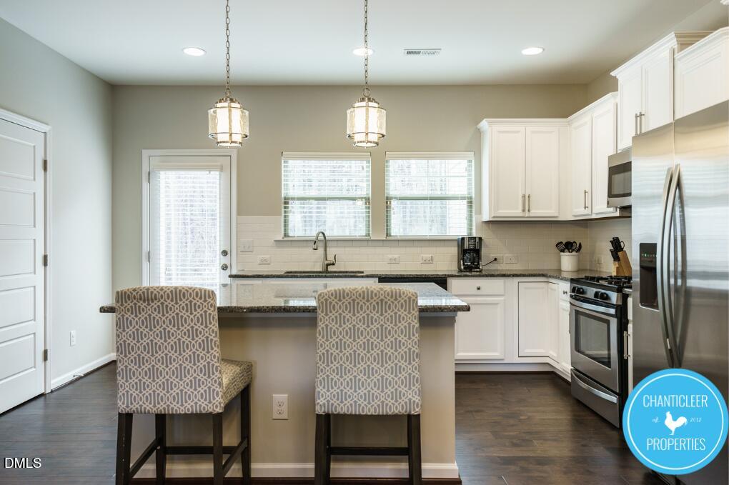 1119 Midtowne Way Durham, NC 27713 - Photo 10 of 26 a kitchen with stainless steel appliances granite countertop a stove a sink a refrigerator dining table and chairs
