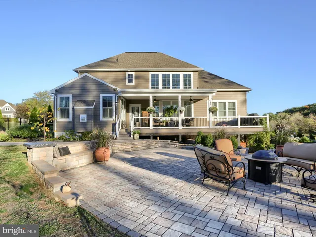 a view of a yard with yellow house in the background