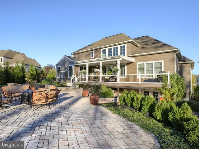 a view of a house with a yard and a bench