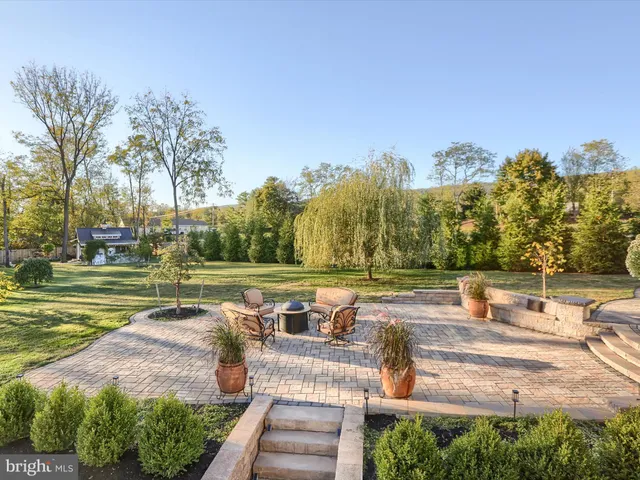 a view of a white house with a small yard and plants