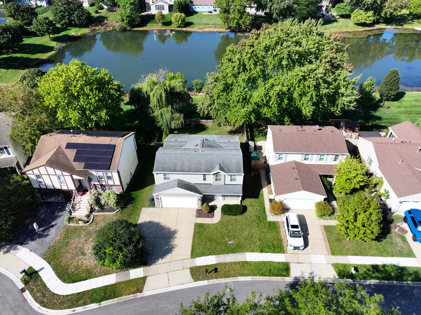 an aerial view of a house with a garden and lake view