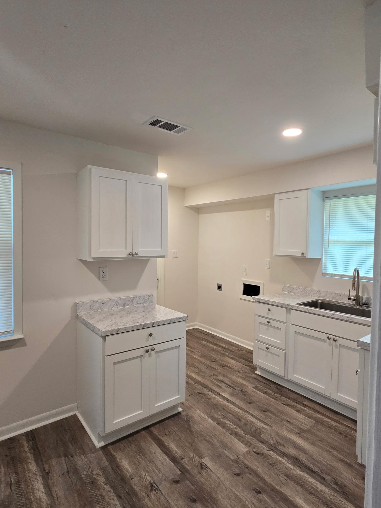 2889 Randy Cove Memphis, TN 38118 - Photo 9 of 18 Kitchen space featuring wood-finish flooring, white cabinetry, and light-toned countertops
