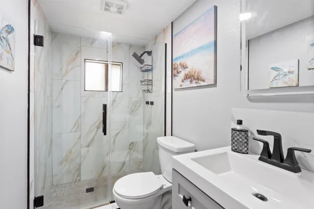 a bathroom with a sink a toilet and shower