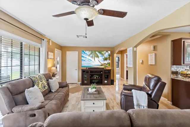 a living room with furniture fireplace and large windows