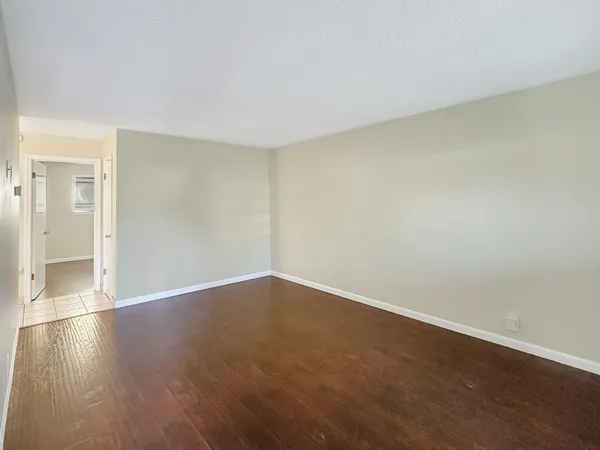 a view of an empty room with wooden floor