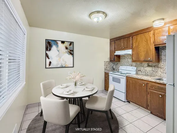 a kitchen with a dining table chairs and white cabinets