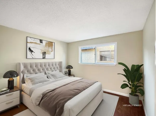 a bedroom with a large bed and a potted plant