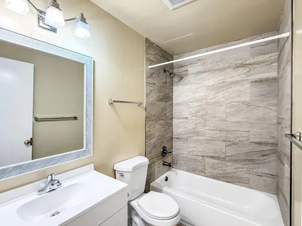 a bathroom with a sink mirror toilet and bathtub