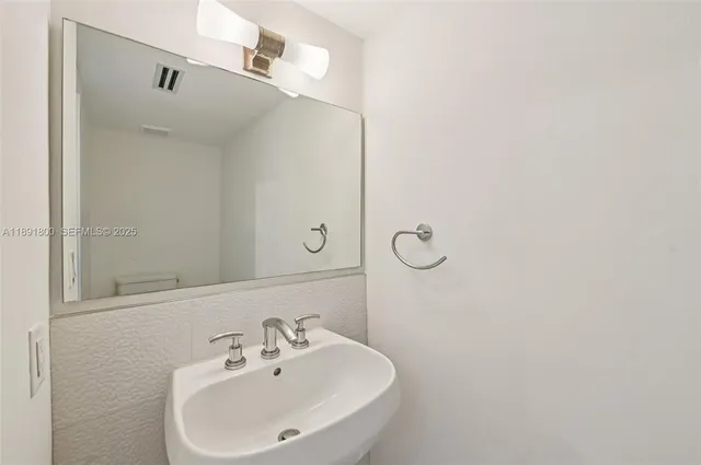 a bathroom with a shower a sink and a mirror