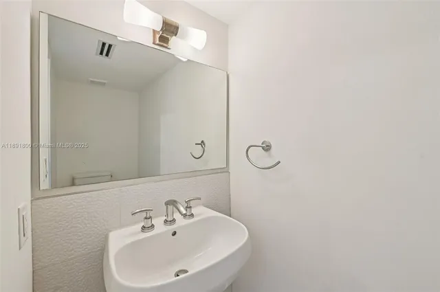 a bathroom with a shower a sink and a mirror