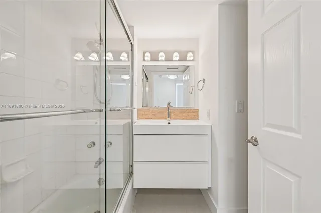 a bathroom with a glass shower door and a glass door