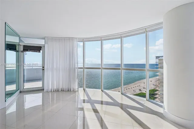 a spacious bedroom with a large window and refrigerator