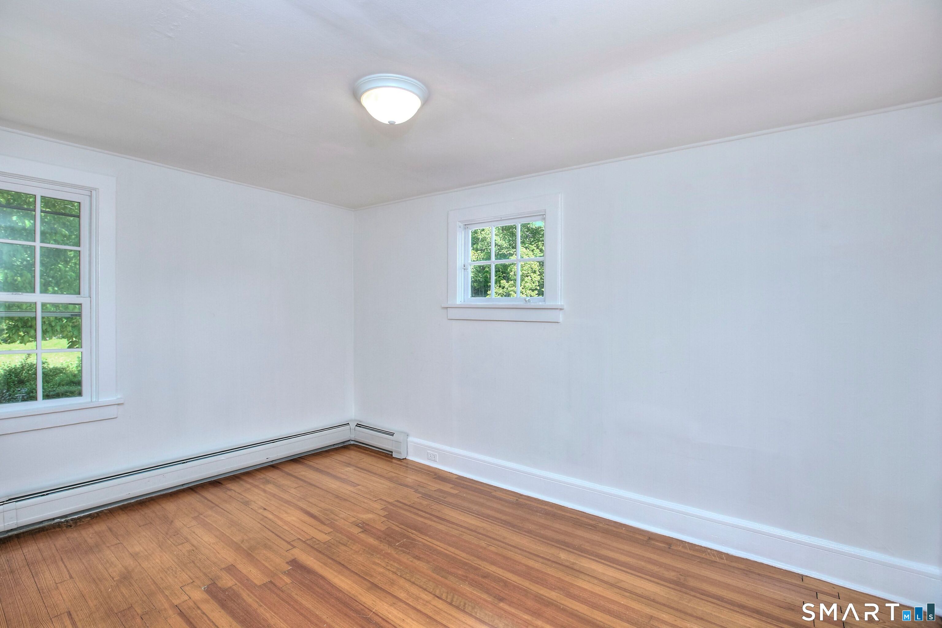 94 Honey Hill Road Wilton, CT 06897 - Photo 14 of 18 an empty room with wooden floor and windows