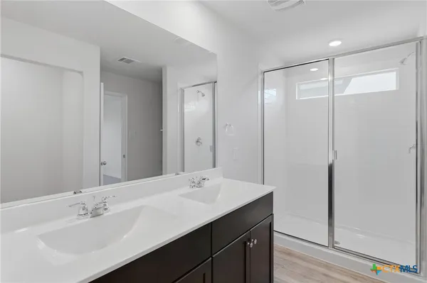 a bathroom with a sink shower and a mirror