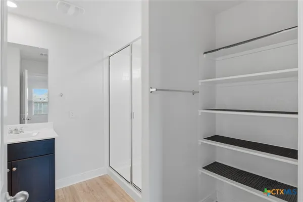 a view of walk in closet with empty racks