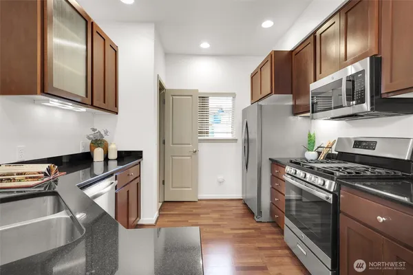 a kitchen with stainless steel appliances granite countertop a refrigerator stove and sink