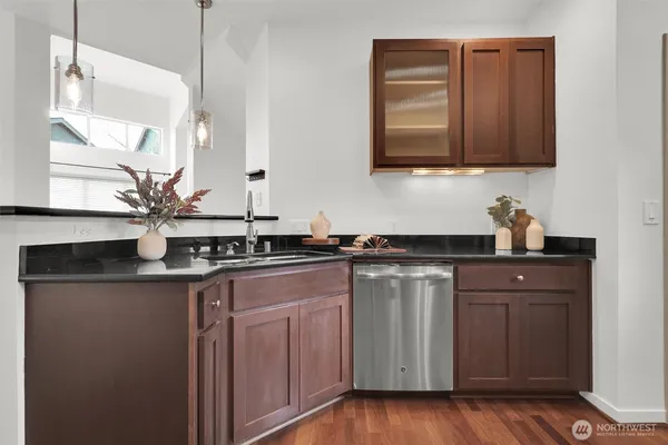 a kitchen with stainless steel appliances granite countertop wooden cabinets a sink and dishwasher