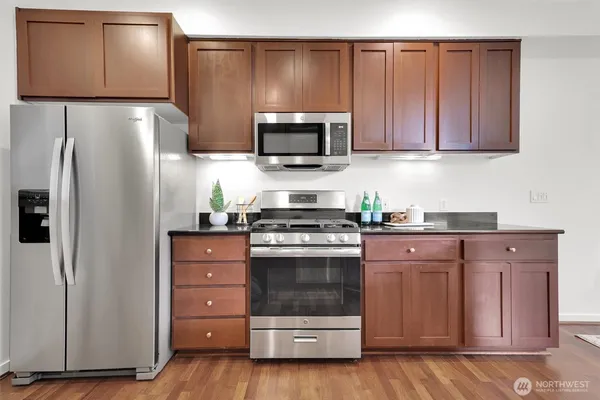 a kitchen with granite countertop stainless steel appliances and wooden cabinets