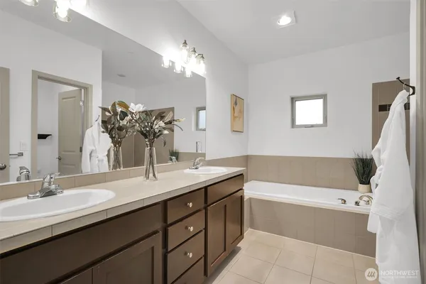 a bathroom with a tub a sink and mirror