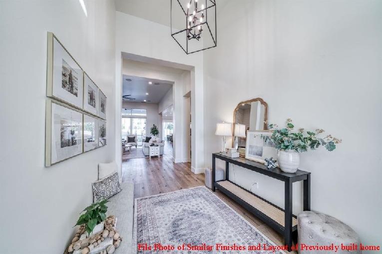 14480 Academy Oaks Lane Clovis, CA 93619 - Photo 13 of 37 a view of a hallway with wooden floor and a potted plant