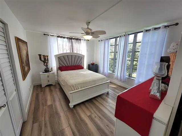 a bedroom with a bed wooden floor and flat screen tv