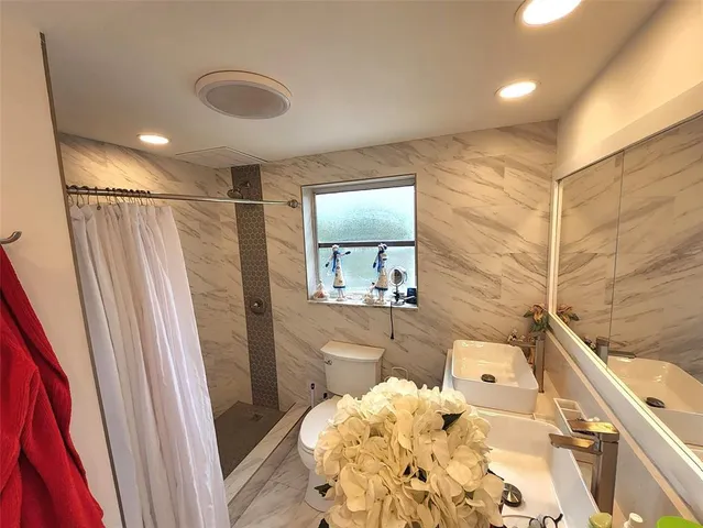 a bathroom with a sink toilet and shower