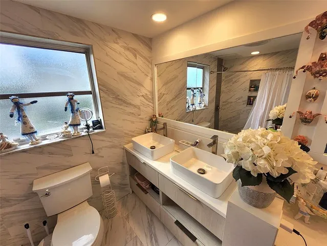 a bathroom with a sink mirror and toilet
