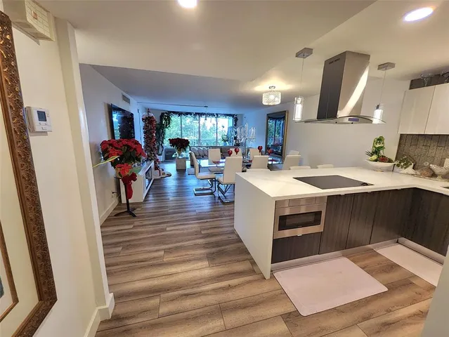 a large white kitchen with sink and a refrigerator