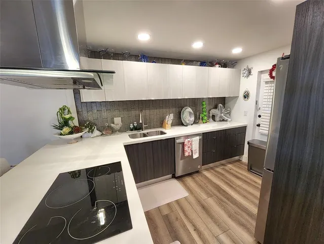 a kitchen with stainless steel appliances a sink stove and cabinets