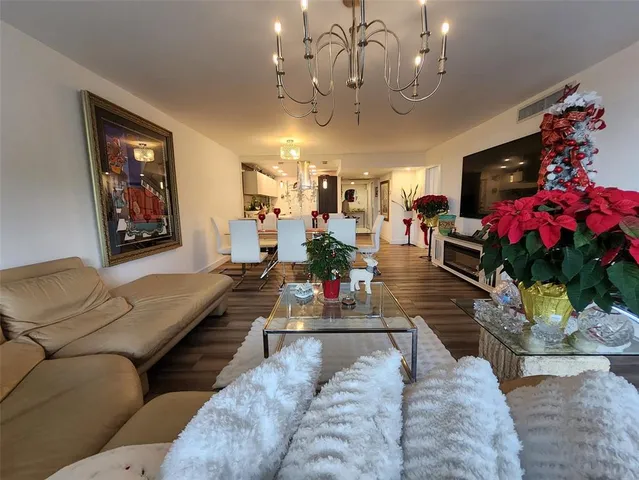 a living room with furniture kitchen and a chandelier