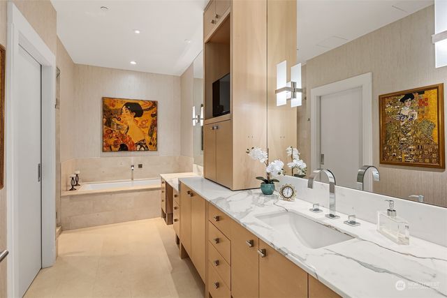 a bathroom with a tub a sink and mirror