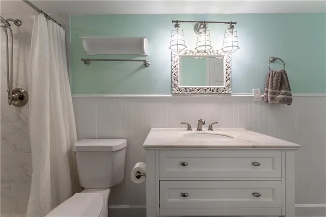 a bathroom with a sink a toilet and shower