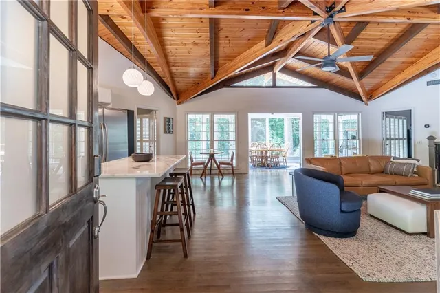 a living room with furniture a wooden floor and next to a window