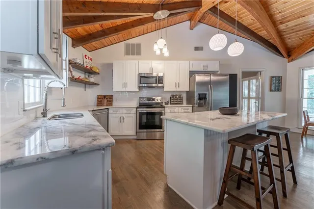 a kitchen with stainless steel appliances granite countertop a stove and cabinets