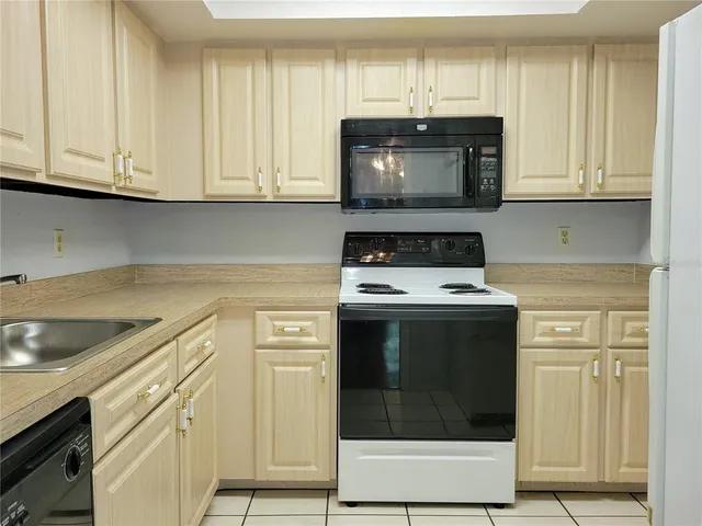 a kitchen with granite countertop white cabinets and stainless steel appliances