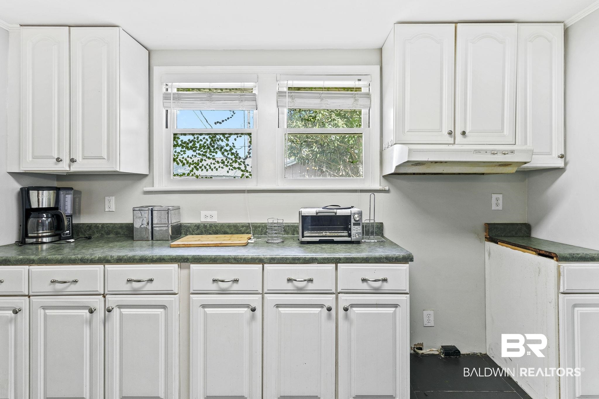 316 West Orchid Avenue Foley, AL 36535 - Photo 29 of 38 Kitchen with dark countertops, white cabinets, and plenty of natural light
