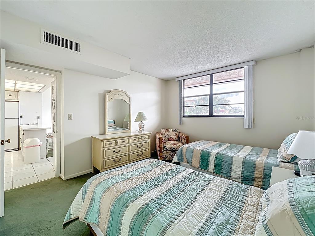 17580 Gulf Boulevard, Unit 219 Redington Shores, FL 33708 - Photo 13 of 47 a bedroom with a bed and a dresser with mirror