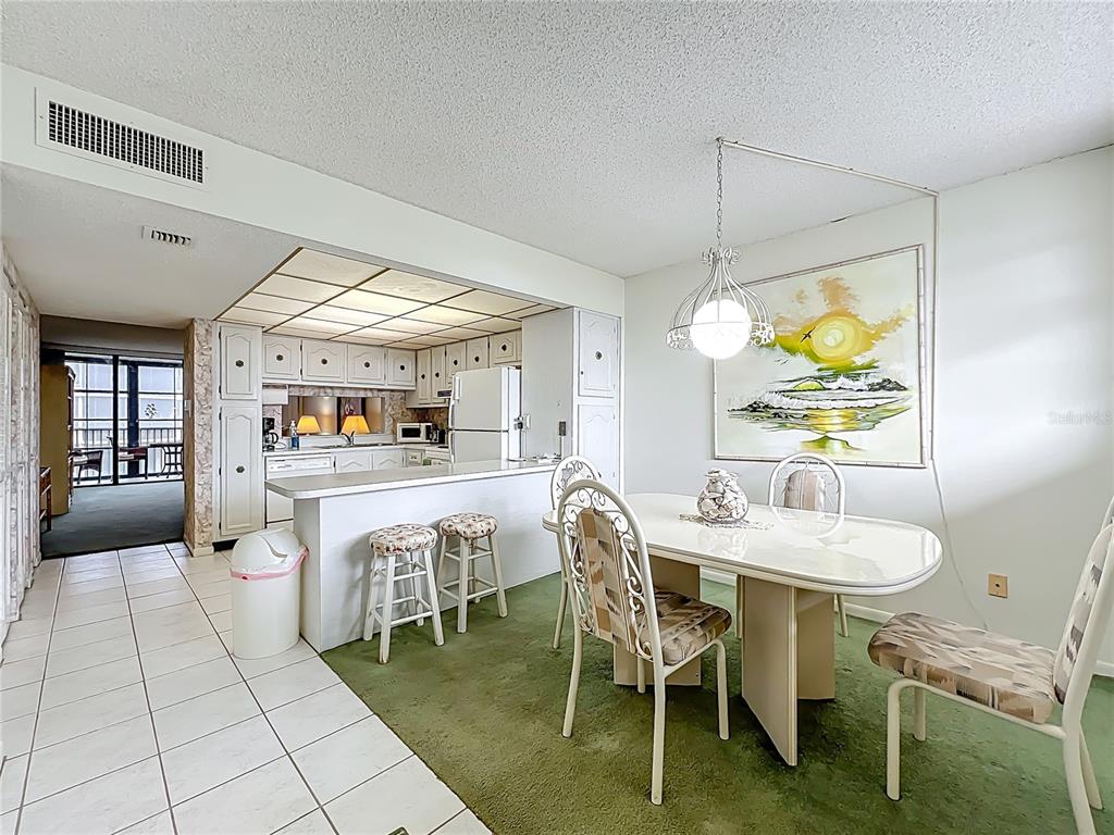 17580 Gulf Boulevard, Unit 219 Redington Shores, FL 33708 - Photo 14 of 47 a dining room with furniture and a floor to ceiling window