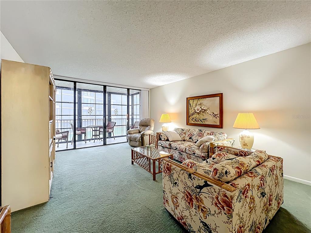 17580 Gulf Boulevard, Unit 219 Redington Shores, FL 33708 - Photo 20 of 47 a living room with furniture and a floor to ceiling window