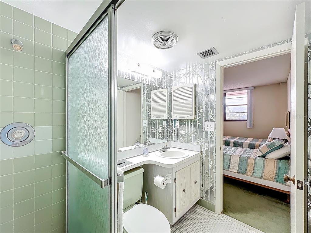 17580 Gulf Boulevard, Unit 219 Redington Shores, FL 33708 - Photo 32 of 47 a bathroom with a double vanity sink mirror and shower