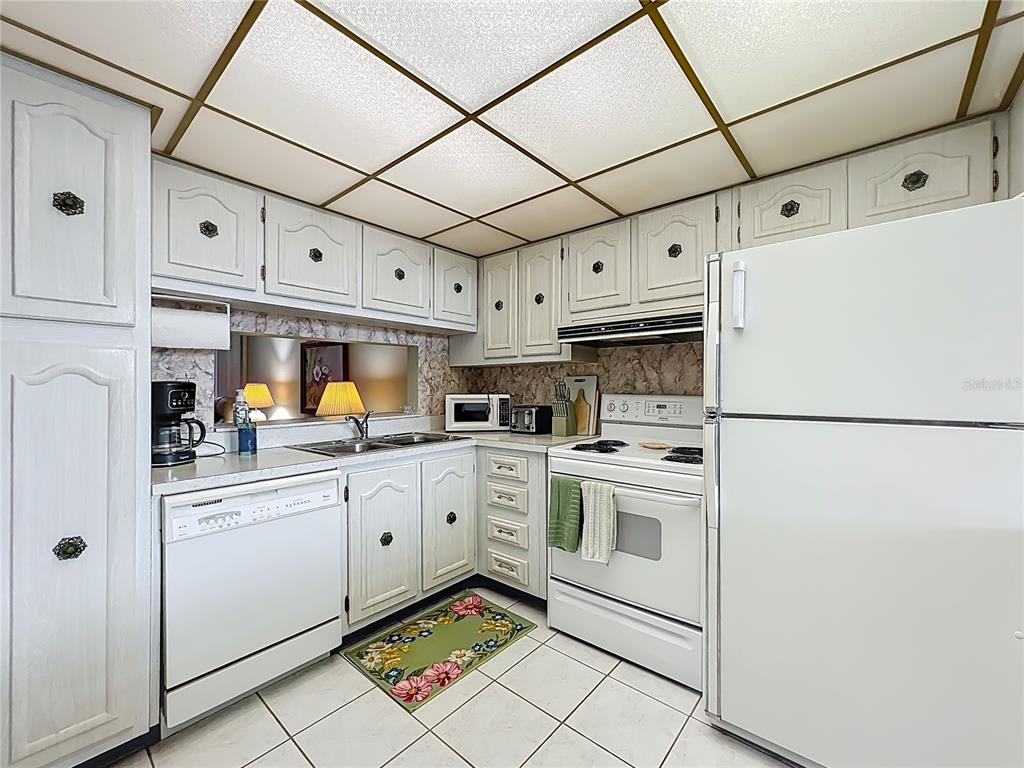 17580 Gulf Boulevard, Unit 219 Redington Shores, FL 33708 - Photo 5 of 47 a kitchen with cabinets appliances and a counter