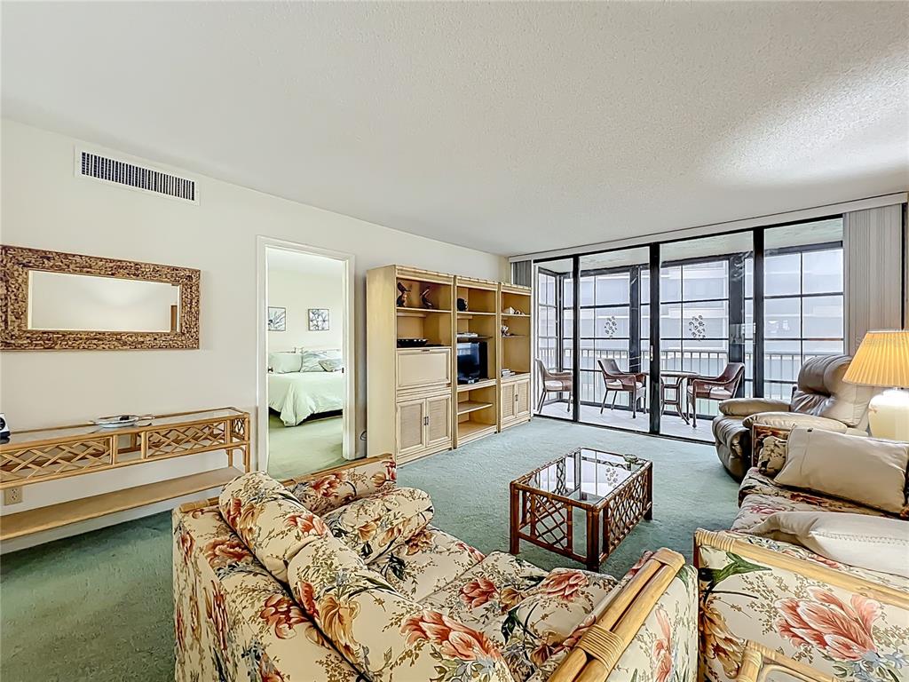 17580 Gulf Boulevard, Unit 219 Redington Shores, FL 33708 - Photo 6 of 47 a living room with furniture and a flat screen tv
