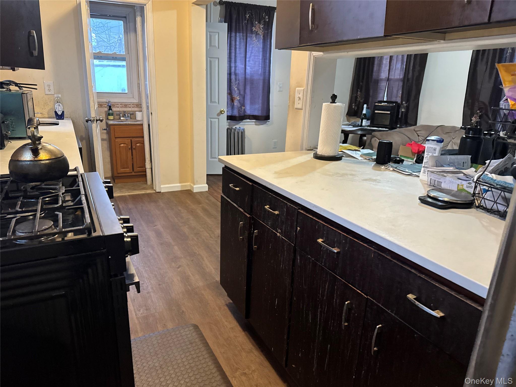 24-31 Deerfield Road Queens, NY 11691 - Photo 6 of 25 Kitchen featuring range with gas stovetop, light countertops, and dark wood-type flooring