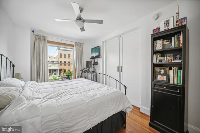 a bedroom with a bed cabinets and a window