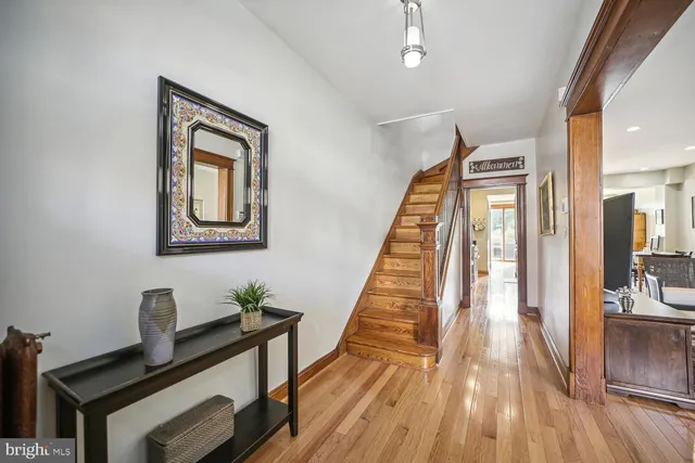 a view of a hallway with wooden floor and staircase